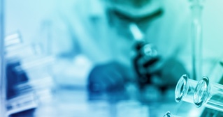 A scientist at a microscope in a laboratory